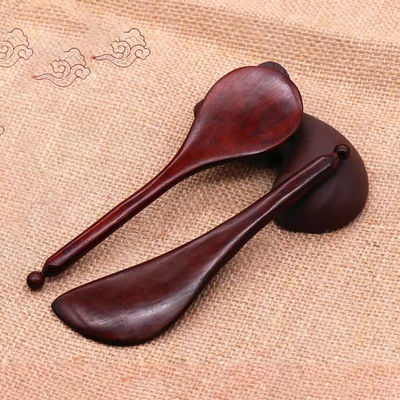 Un stylo en bois de rose rouge à forme de gua est disponible pour les massages corporels et l'acupuncture