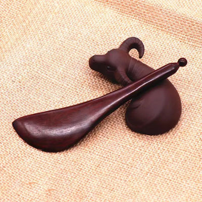 Un stylo en bois de rose rouge à forme de gua est disponible pour les massages corporels et l'acupuncture