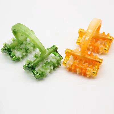 Appareil de massage à rouleaux en plastique avec poignée pour le massage facial.