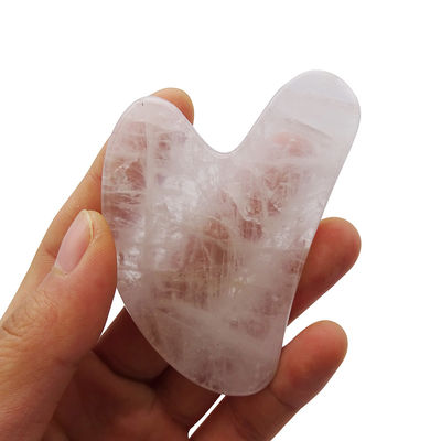 Massage facial en forme de cœur, pierre Gua Sha cristalline blanche pour l'acupuncture au centre de médecine traditionnelle chinoise.