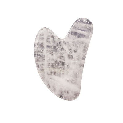 Massage facial en forme de cœur, pierre Gua Sha cristalline blanche pour l'acupuncture au centre de médecine traditionnelle chinoise.