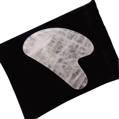 Massage facial en forme de cœur, pierre Gua Sha cristalline blanche pour l'acupuncture au centre de médecine traditionnelle chinoise.