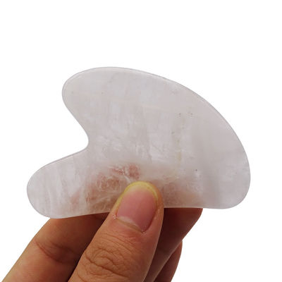 Massage facial en forme de cœur, pierre Gua Sha cristalline blanche pour l'acupuncture au centre de médecine traditionnelle chinoise.