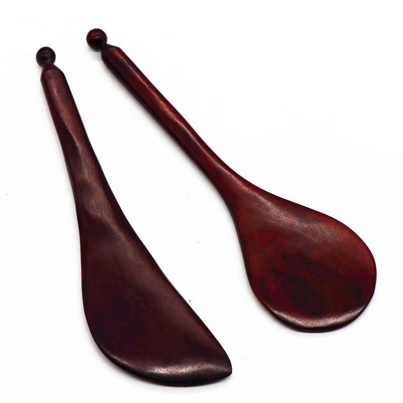 Un stylo en bois de rose rouge à forme de gua est disponible pour les massages corporels et l'acupuncture